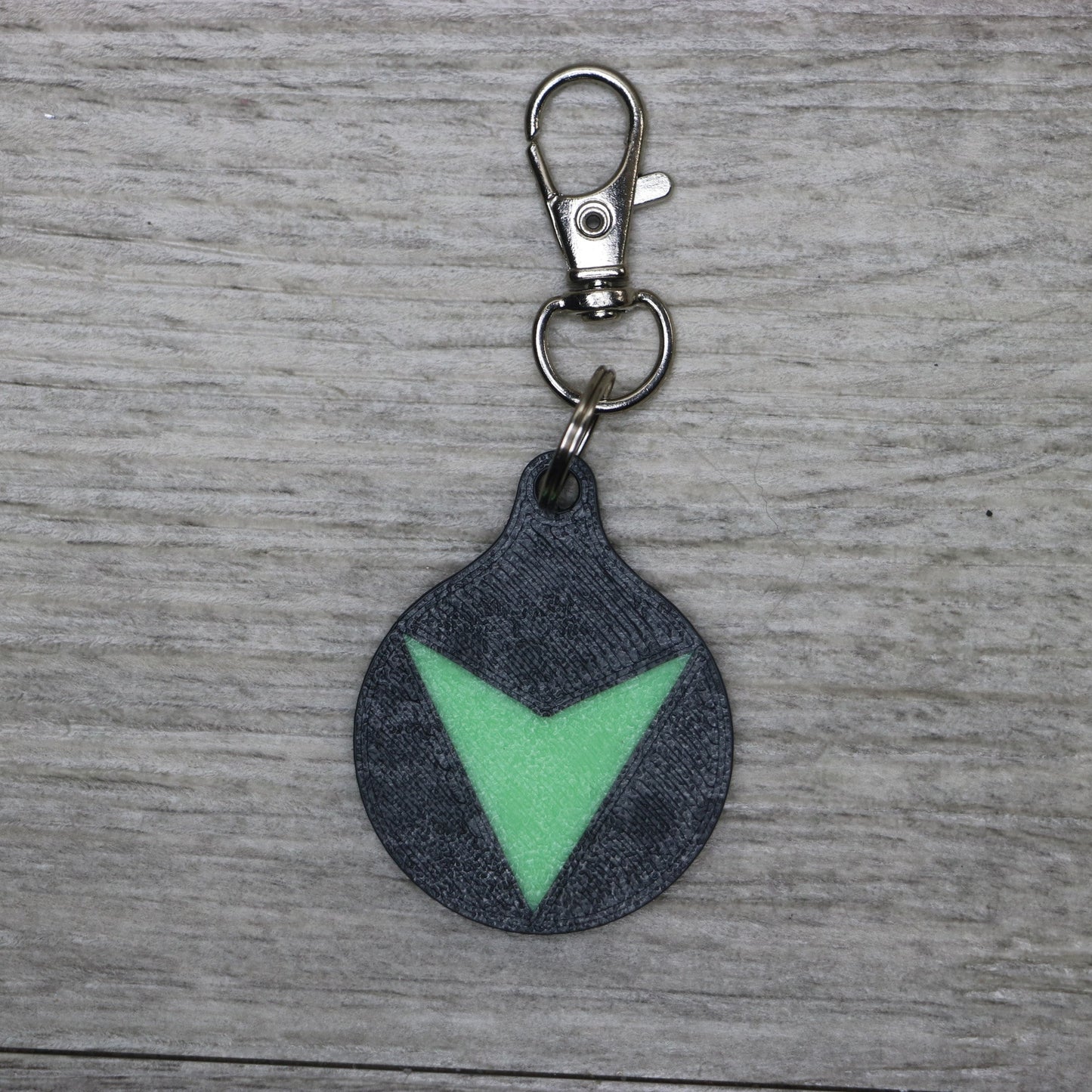 Dark Wobble Keychain with green triangle design on gray background