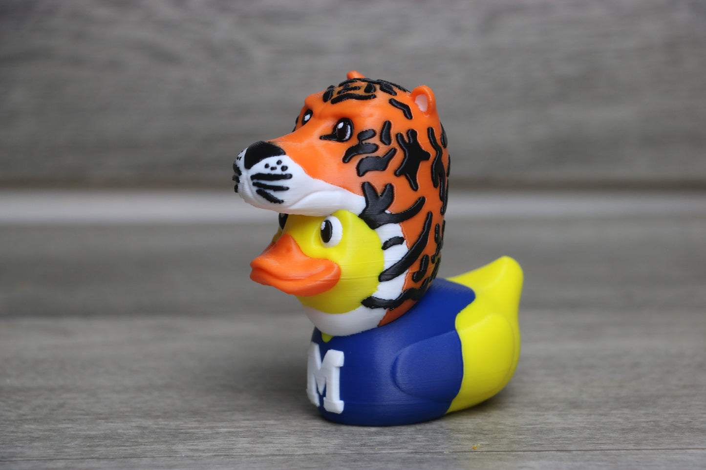 Rubber duck with tiger design on a gray surface
