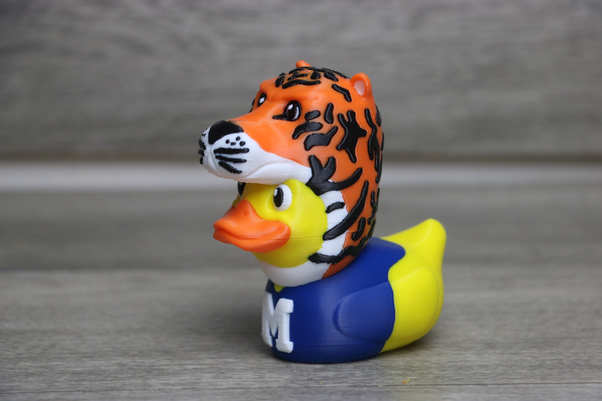 Rubber duck with tiger design on a gray surface
