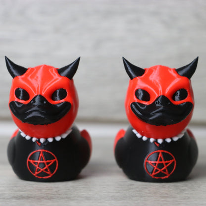 Two red and black cat figurines with pentacle symbols on a neutral background