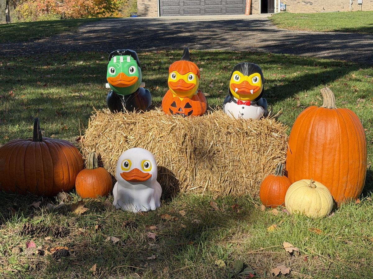 All the giant Halloween ducks together on a hay bale with pumpkins
