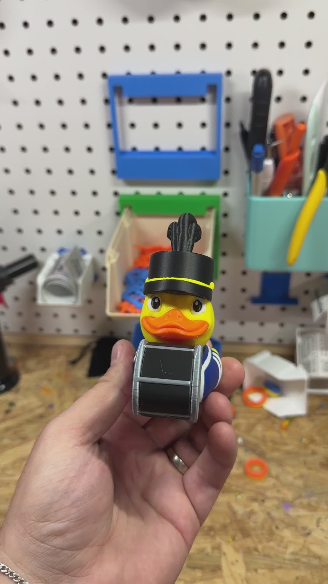 Band Drummer Duck turned in hand to show the plumed hat, striped band uniform and bass drum from every side