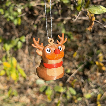 Reindeer duck ornament hanging outdoors among green and yellow leaves